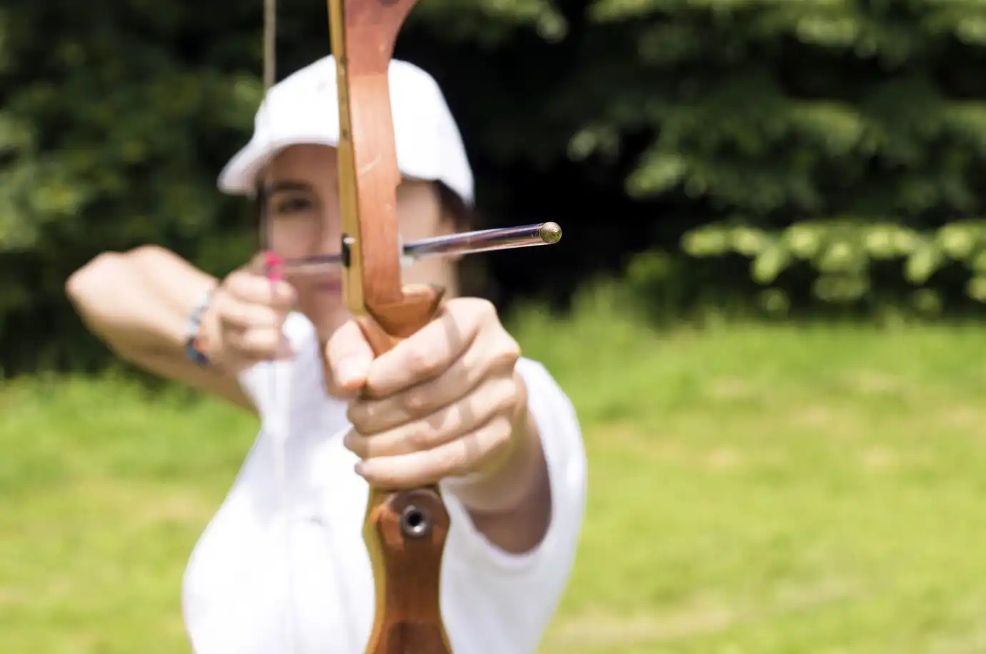 blurred-shot-female-archer-holding-wooden-bow-aiming-target_181624-40397